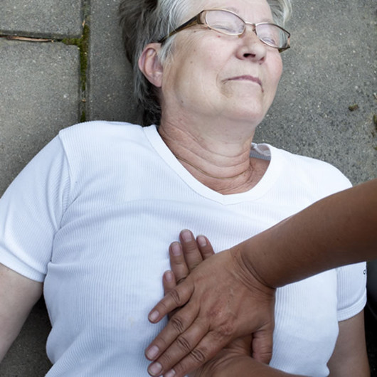 someone performing CPR on an woman on the floor