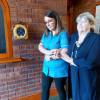heartsine samaritan pad 350p defibrillator mounted on wall with carer walking while supporting person