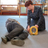 Person kneeling on floor opening the case of a heartsine samaritan pad 350p defibrillator