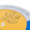 a close up view of the top of the trainer unit stating Heart samaritan PAD with a bright yellow front with a picture stating where the pads should be placed on the patient