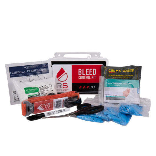 a rectangular white hard plastic case with the words bleed control pro on it. In front are the contents of the kit including tourniquet gloves and specialist bleed control bandages
