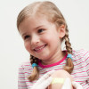 a young child smiling with a plaster being applied to her knee