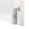 close up of the round magnet that if flush mounts to the door of a white cabinet 