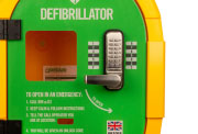 A close-up of a green and yellow defibrillator cabinet
