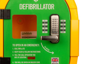 A close-up of a green and yellow defibrillator cabinet
