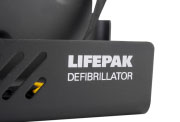 A close-up of a dark grey defibrillator wall bracket