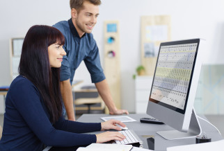 2 office workers looking at a computer screen
