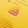 A close-up of the shock LED on a yellow defibrillator