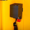 a close up shot of the internal black box that houses the heating for the yellow cabinet underneath is a black cable to be connect to the mains electric supply