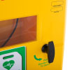 a close up of the wing nut style black handle on a yellow defibrillator cabinet underneath the handle in green writing it says pull handle down to open