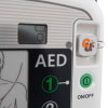A close-up of the green power button on a white defibrillator