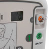 A close-up of the green power button on a white defibrillator