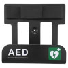 A black AED wall bracket with white text and a green logo