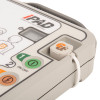 Close-up of iPAD AED showing ON/OFF button, shock button, pad connector, and illustrated pad placement guide.