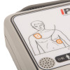 AED panel showing electrode pad placement diagram for adults, with speaker grille and age suitability icon.