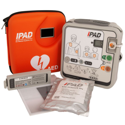 AED kit including iPAD defibrillator, orange carry case, battery pack, user manual, and starter kit with CPR accessories.