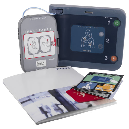 A dark and light blue defibrillator with all of the kit contents