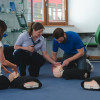 a trainer showing how to tilt the head back to perform effective rescue breaths on a manikin