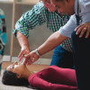 a trainer showing how to tilt a head back on a volunteer
