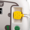 Close-up of a white device featuring a yellow connector port, a green power button, and a large printed number one