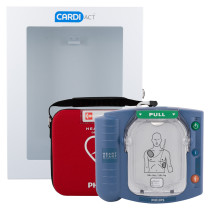 A Philips HeartStart AED sits next to its red carrying case, both positioned in front of a white wall‑mounted Cardiact cabinet. The blue defibrillator shows a pull handle and a diagram illustrating correct pad placement on the chest.