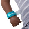 Close-up of a dark skin arm with a blue Bluetooth bracelet from the laerdal little baby qcpr training manikin with carry bag