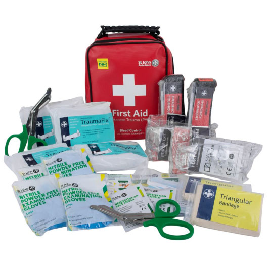 a red plastic carry case with black handle on the front is a white cross and the words first aid. In the front it shows the entire contents of the trauma kit including bandages gloves and torniquets