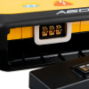 Close‑up of an AED connector port with three metallic contacts inside a rectangular socket, surrounded by yellow and black casing.