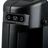 Close‑up of a three‑pin electrical connector recessed into a textured black device housing with visible screws and moulded contours.