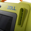 A close-up of the electrode pad connection port on the front of a bright green defibrillator